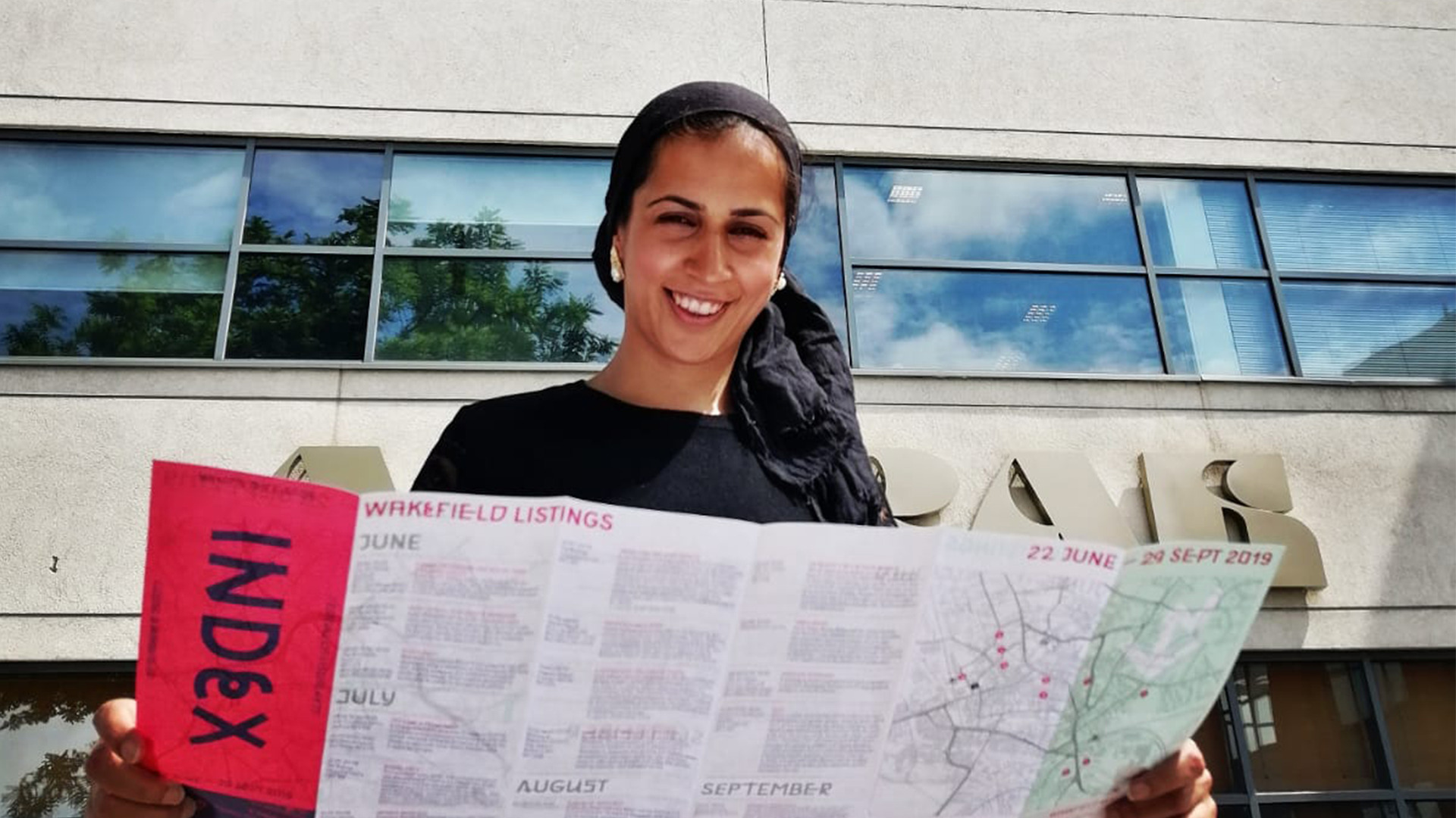 A photograph of Community Reporter Sabbiyah Pervez outside BBC Yorkshire in Leeds holding Index Festival programme